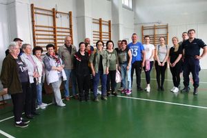 Grupa osób uczestniczących w zajęciach samoobrony prowadzonych przez policjantów.