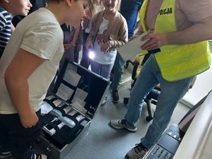 Uczniowie obserwują pracę technika kryminalistyki.
