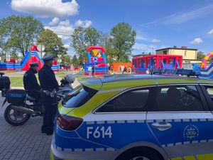 Policjanci ruchu drogowego uczestniczą w pikniku rodzinnym na terenie szkoły.