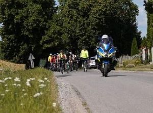 Policyjny motocykla prowadzi rajd rowerowy