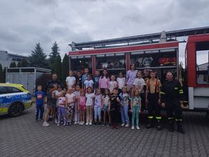 Policjant i strażacy na spotkaniu z dziećmi przebywającymi na półkoloniach.