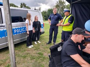 Dwóch policjantów rozmawia z dwiema kobietami.