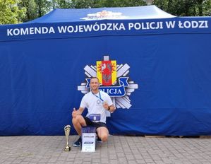 Policjant z pucharem po zakończonym biegu.