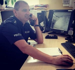 Policjant rozmawia przez telefon.