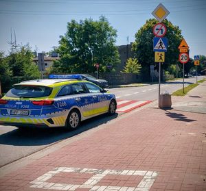 Policyjny radiowóz przy przejściu dla pieszych.