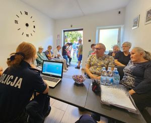 Policjantki siedzą w sali z seniorami.