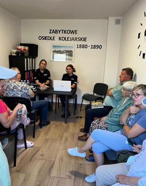 Policjantki siedzą w sali z seniorami.