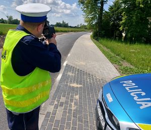 Policjant mierzy prędkość na drodze.