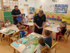 Policjanci rozdają odblaski uczniom.