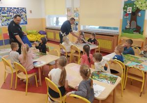 Policjanci rozdają odblaski uczniom.