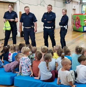 Policjanci stoją obok dzieci.