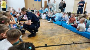 Policjanci rozdają odblaski przedszkolakom.