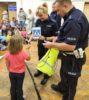 Policjanci rozdają odblaski przedszkolakom.