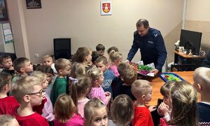 Komendant komisariatu przyjmuje dzieci z przedszkola w swoim gabinecie.