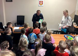 Komendant komisariatu przyjmuje dzieci z przedszkola w swoim gabinecie.