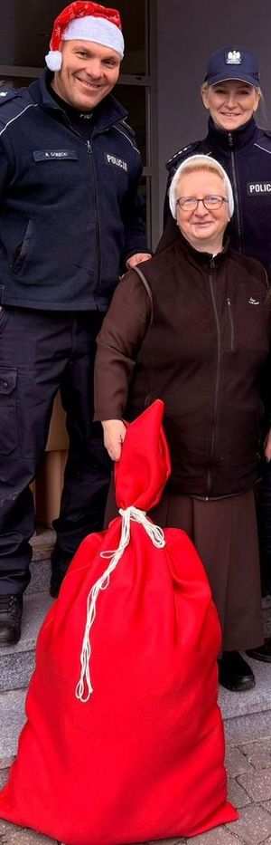 Policjanci przekazują prezenty siostrze zakonnej dla podopiecznych.