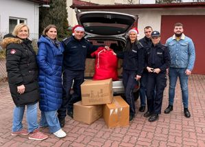 Policjanci przekazują prezenty siostrze zakonnej dla podopiecznych.