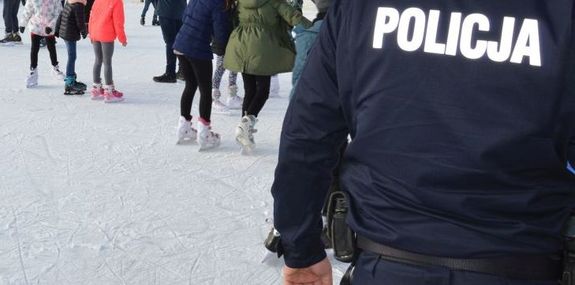 Policjant stoi na lodowisku.