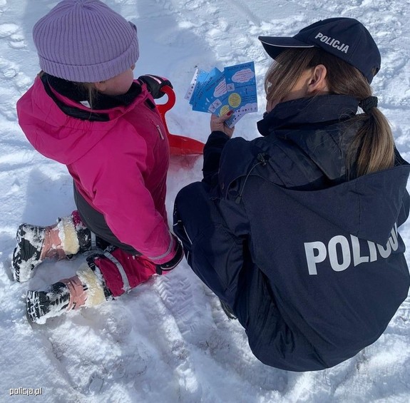 Policjantka rozmawia z małym dzieckiem.