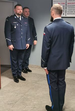 Prcownicy i policjanci stoją na sali podczas uroczystości Swięta Służby Cywilnej.