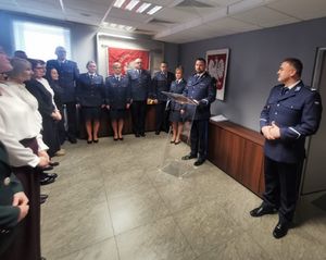 Prcownicy i policjanci stoją na sali podczas uroczystości Swięta Służby Cywilnej.