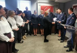 Prcownicy i policjanci stoją na sali podczas uroczystości Swięta Służby Cywilnej.