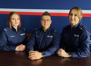 Troje dzielnicowych siedzi przy stole.