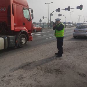 Policjanci stoją przy drodze i mierzą prędkość.