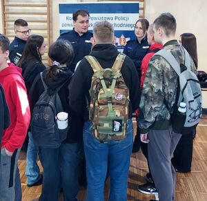 Policjanci promują zawód w szkole średniej.