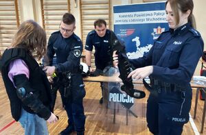 Policjanci promują zawód w szkole średniej.