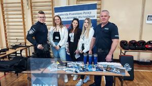 Policjanci promują zawód w szkole średniej.