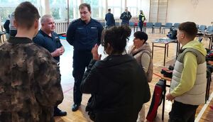 Policjanci promują zawód w szkole średniej.