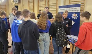 Policjanci promują zawód w szkole średniej.