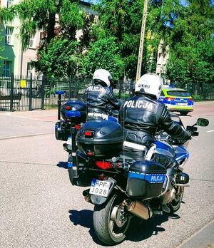 Dwóch policjantów jedzie motocyklami.