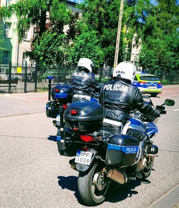 Dwóch policjantów jedzie motocyklami.