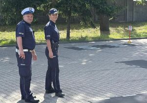 Policjanci egzaminują uczniów szkoły podstawowej na kartę rowerową.