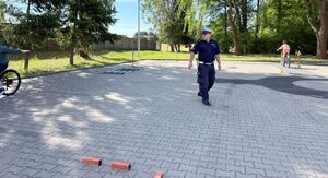 Policjanci egzaminują uczniów szkoły podstawowej na kartę rowerową.