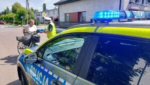 Policjanci przekazują kaski rowerzystą.