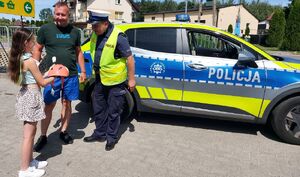 Policjanci przekazują kaski rowerzystą.