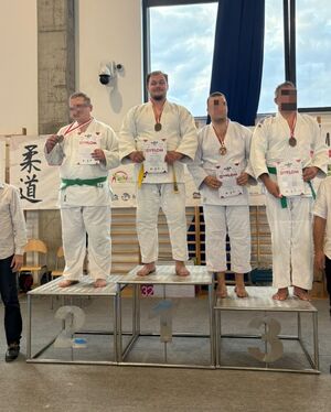 Na podium stoją zwycięzcy w judo.