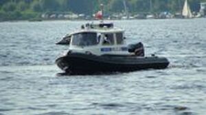 Policyjna motorówka płynie po wodzie i patroluje obiekt wodny